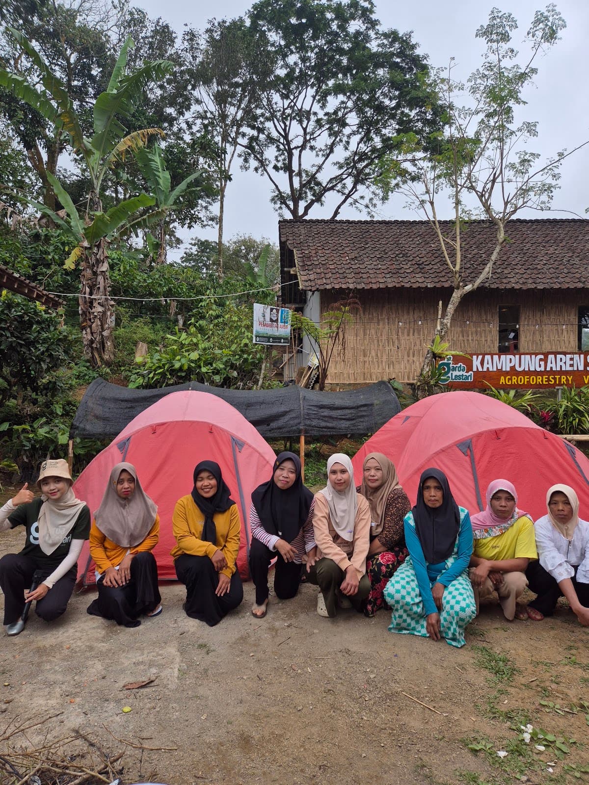 Ibu-Ibu Srikandi Kampung Aren Simacan berfoto di depan dua tenda yang berhasil didirikan